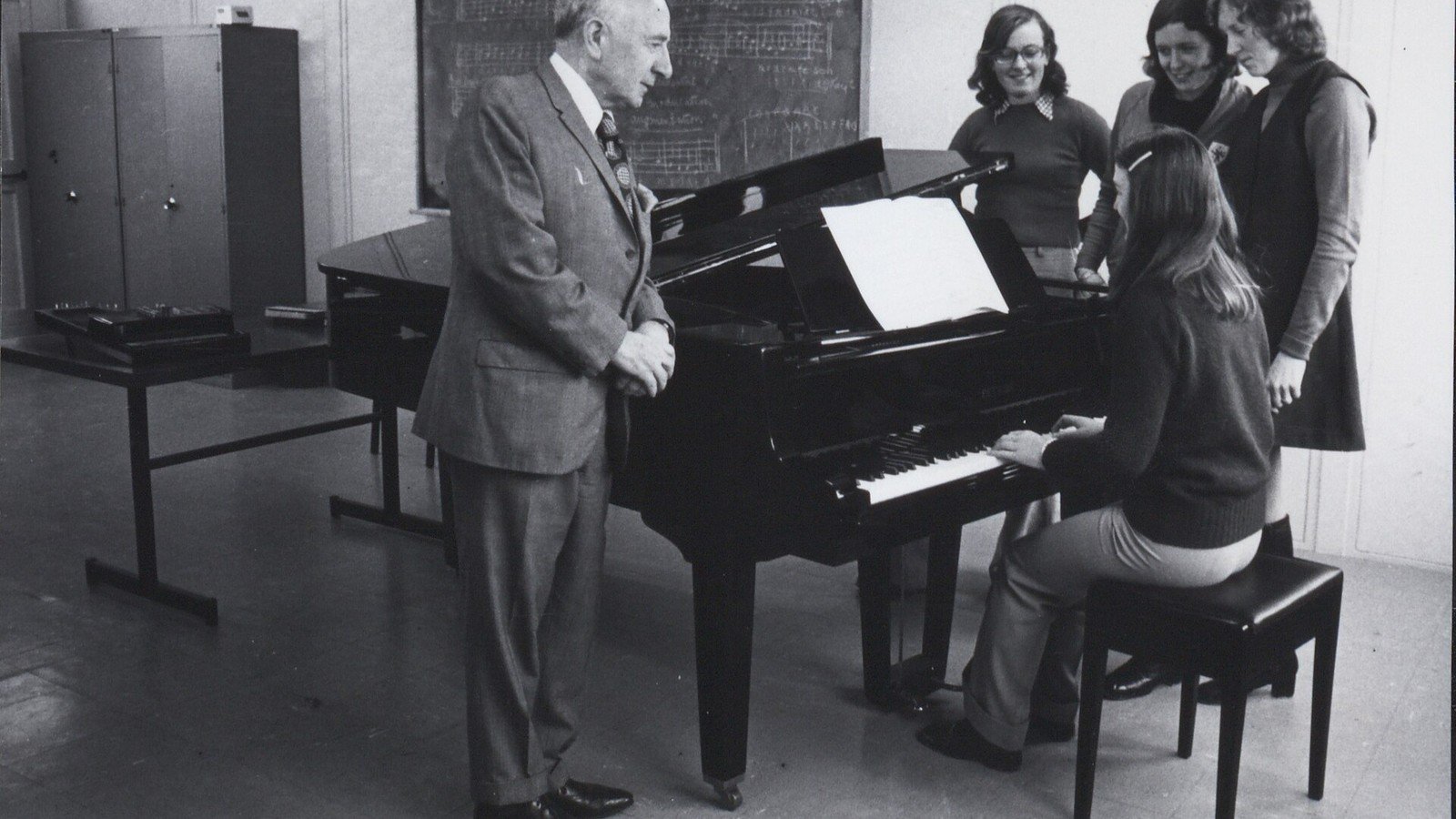 Professor orienta aluna adulta durante aula de piano